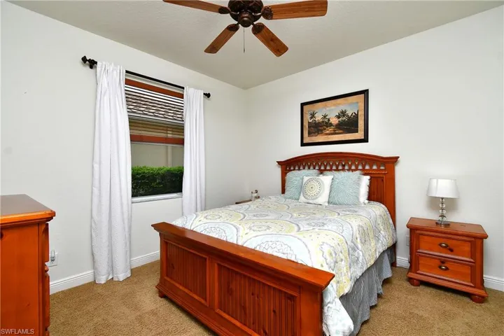 Carpeted bedroom featuring baseboards and ceiling fan