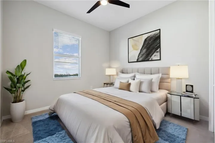 Bedroom with ensuite bath, light colored carpet and ceiling fan