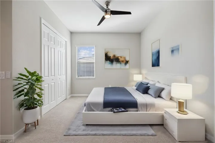 Carpeted bedroom featuring a closet and ceiling fan