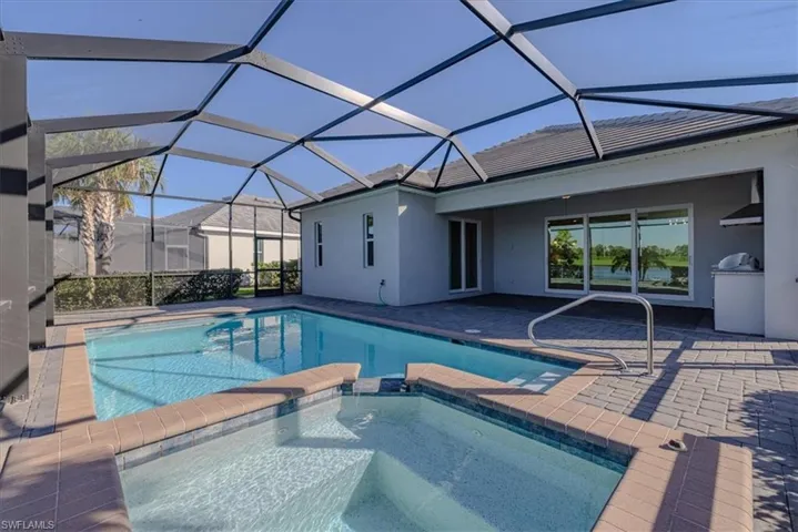 View of pool with an in ground hot tub, a patio area, and a lanai