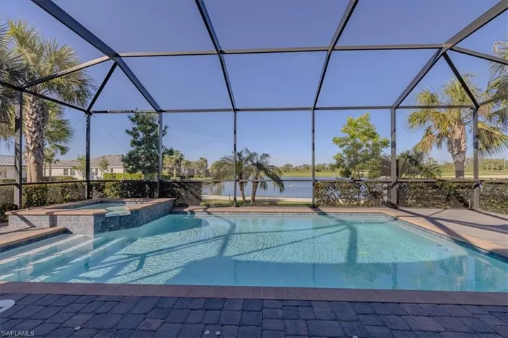View of pool with an in ground hot tub and screen enclosure