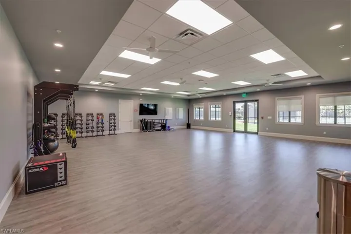 Workout room featuring a drop ceiling, wood-type flooring, and ceiling fan