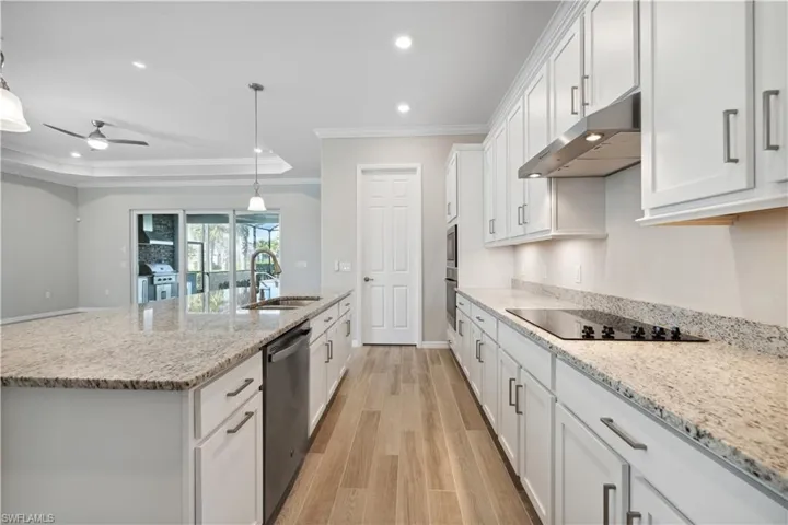 Kitchen featuring stainless steel appliances, light hardwood / wood-style floors, sink, and ornamental molding