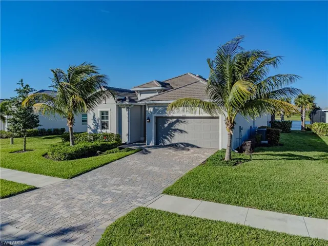 View of front of house featuring a garage and a front lawn