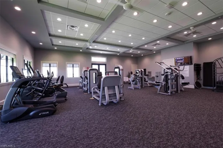 Community Exercise room featuring carpet and coffered ceiling