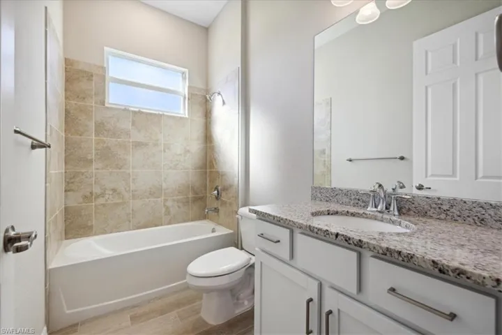 Full bathroom featuring toilet, vanity, and tiled shower / bath