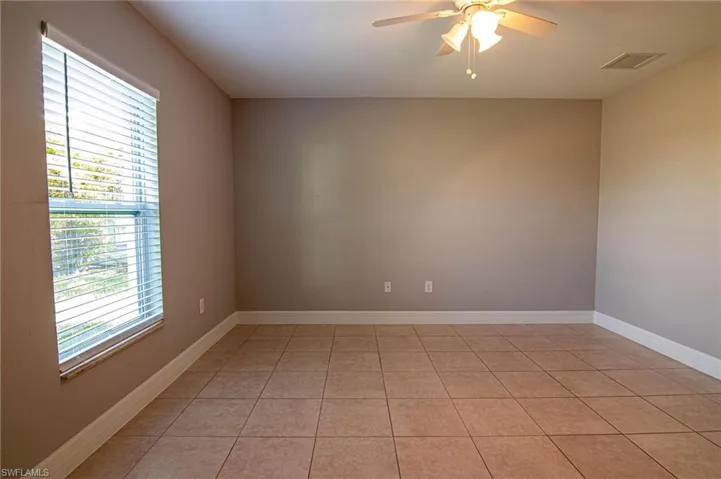 Unfurnished room featuring ceiling fan and light tile patterned flooring