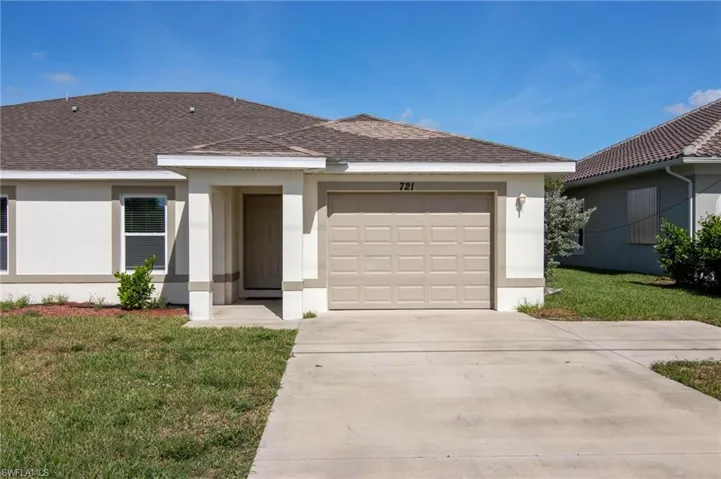 Ranch-style home featuring a front yard, roof with shingles, and stucco siding