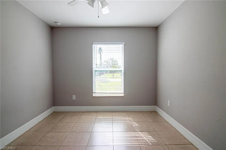 Spare room with light tile patterned floors and a ceiling fan