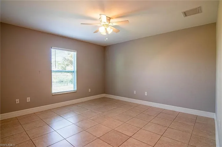 Spare room with light tile patterned floors and a ceiling fan