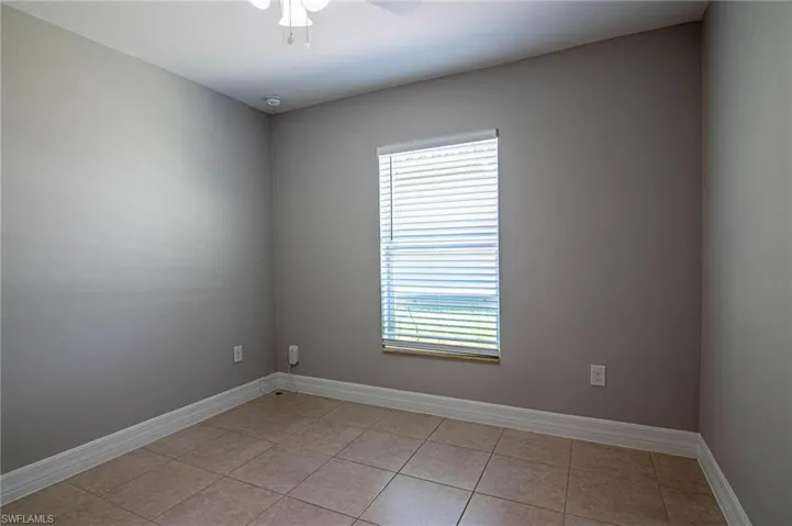 Spare room with ceiling fan and light tile patterned flooring