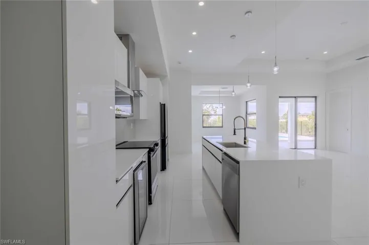 Kitchen featuring modern cabinets, white cabinetry, a sink, dishwasher, and light tile patterned flooring