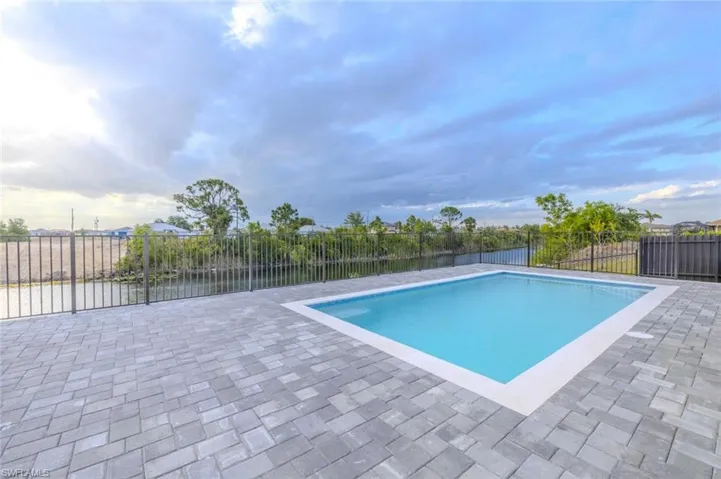 View of pool with a fenced in pool, fence, and a patio area