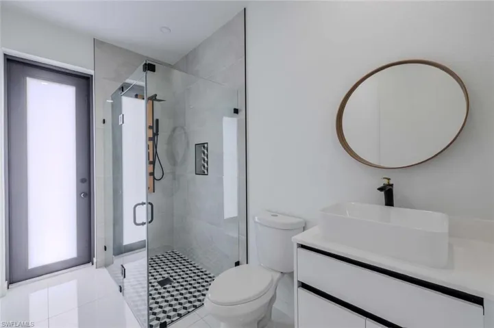 Full bath featuring toilet, a stall shower, and vanity