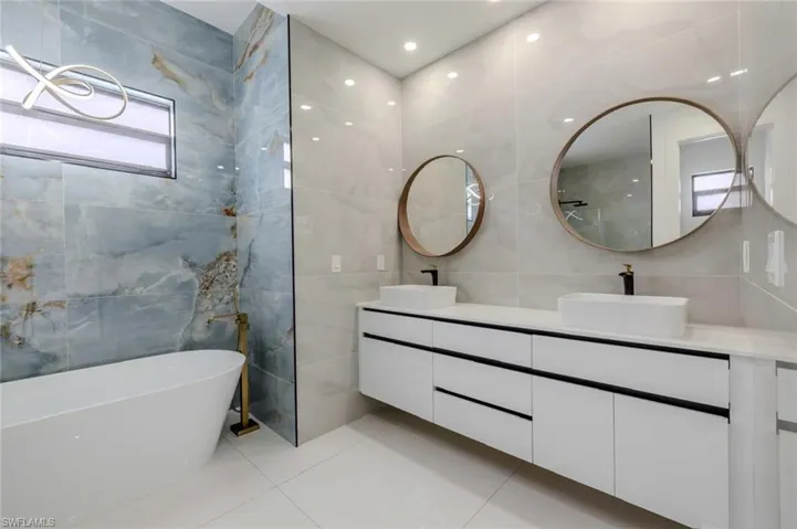 Full bathroom with tile patterned flooring, a sink, and tile walls