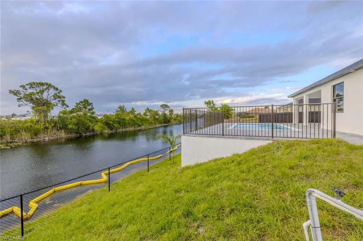 View of yard with a water view, fence, a patio area, and a fenced in pool