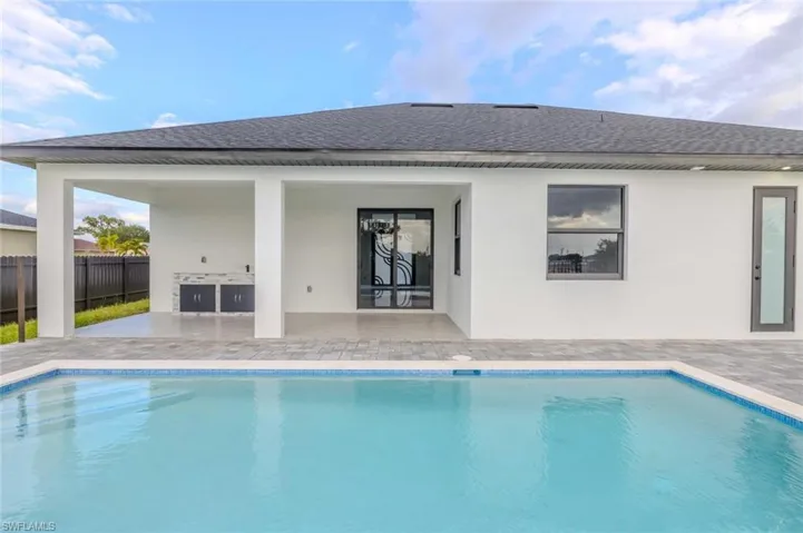 Back of house featuring a patio, a fenced in pool, fence, and roof with shingles