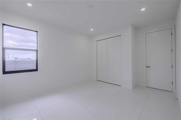 Unfurnished bedroom with recessed lighting, light tile patterned flooring, and a closet