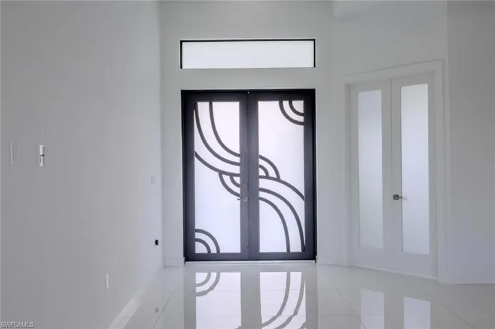 Foyer entrance with a healthy amount of sunlight, tile patterned floors, and french doors
