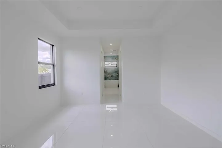 Empty room with a tray ceiling and light tile patterned floors