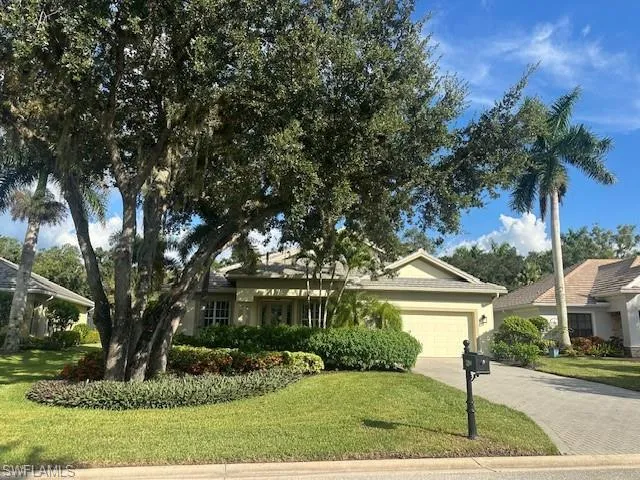 Single story home with a front yard, a garage, driveway, and stucco siding