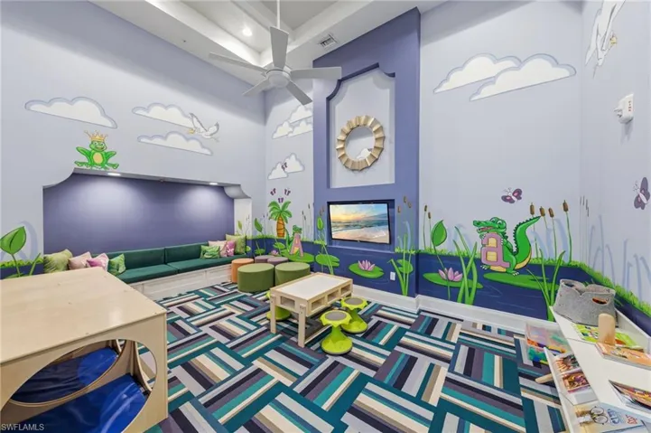 Rec room with a ceiling fan and a high ceiling