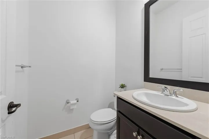 Half bath featuring vanity and light tile patterned floors
