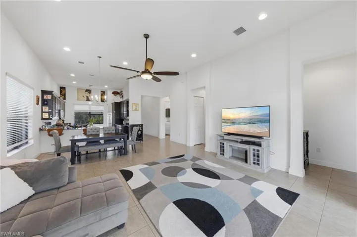 Living room featuring recessed lighting, a ceiling fan, a high ceiling, and light tile patterned floors