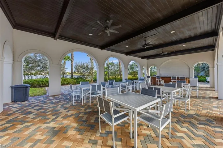 View of patio with outdoor dining area and ceiling fan
