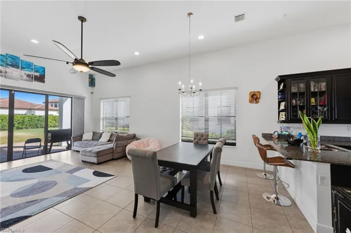 Dining room featuring ceiling fan, light tile patterned floors, a high ceiling, and hanging lights