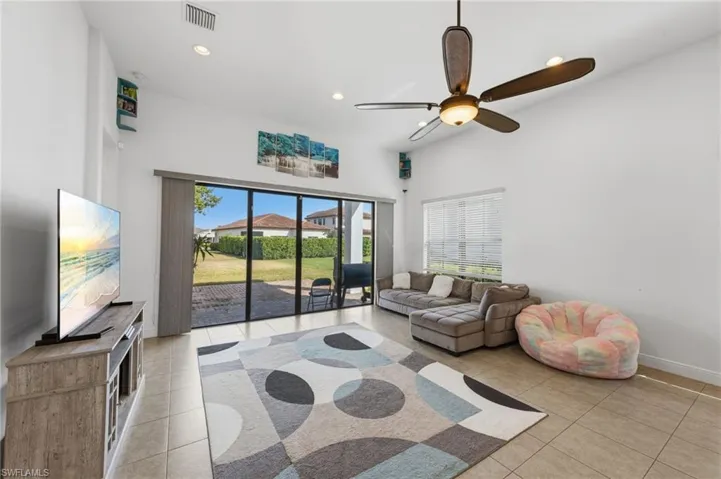 Living area featuring recessed lighting, a ceiling fan, a high ceiling, and light tile patterned flooring