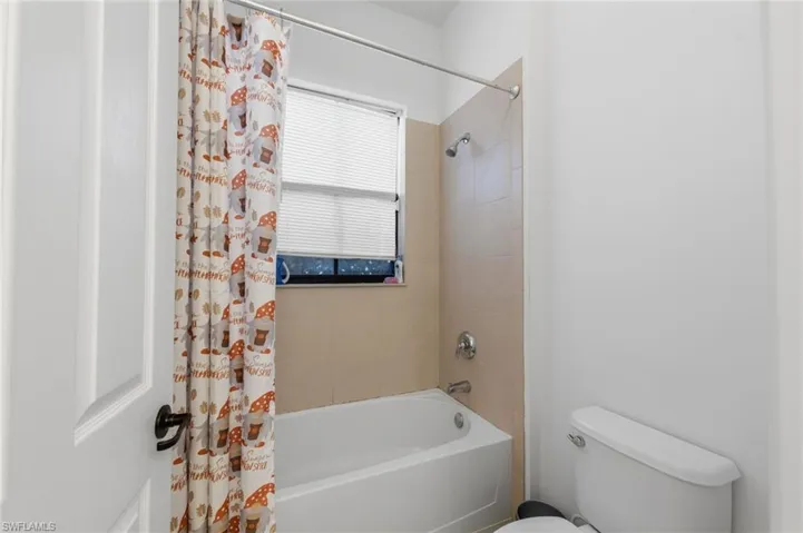 Full bath featuring toilet and shower / tub combo