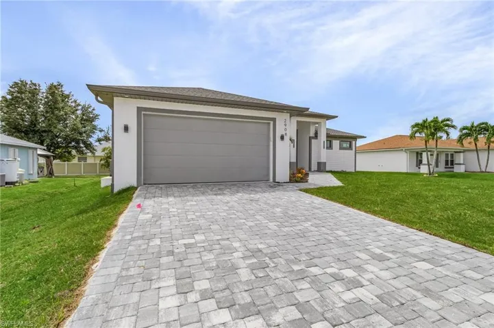 View of front of house with a front yard and a garage