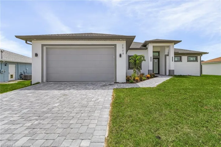 View of front of property featuring a garage, central AC unit, and a front yard