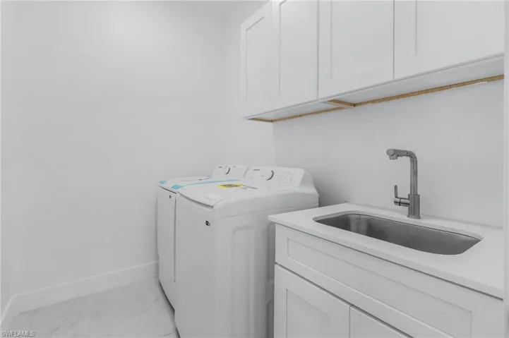 Laundry area with cabinets, sink, and washer and dryer