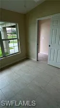 Spare room featuring lofted ceiling and baseboards