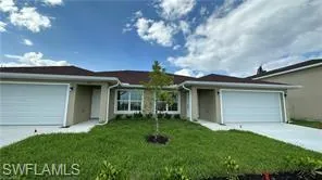 Ranch-style house featuring a front lawn, a garage, and driveway