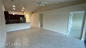 Unfurnished living room with lofted ceiling and ceiling fan