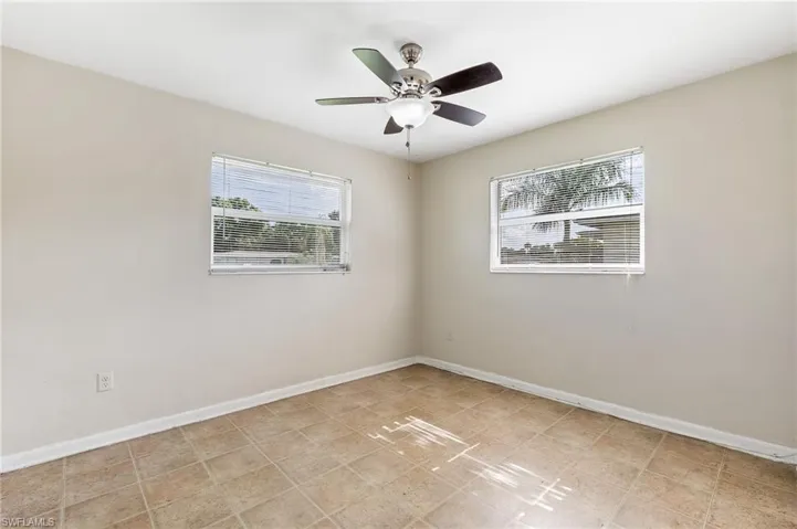 Empty room featuring baseboards and a ceiling fan
