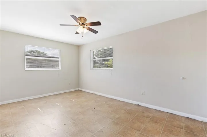 Empty room featuring baseboards and a ceiling fan