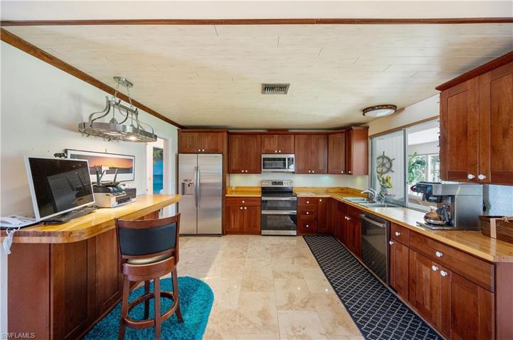 Stainless steel appliances with cherry wood cabinets.