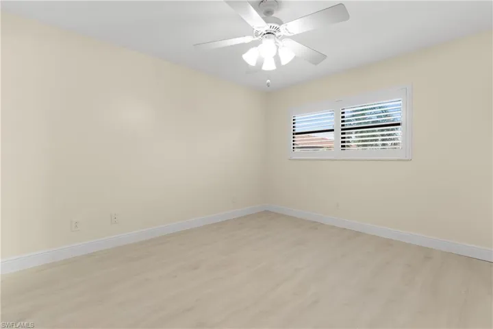Primary Bedroom has Plantation Shutters on window and door to rear patio.