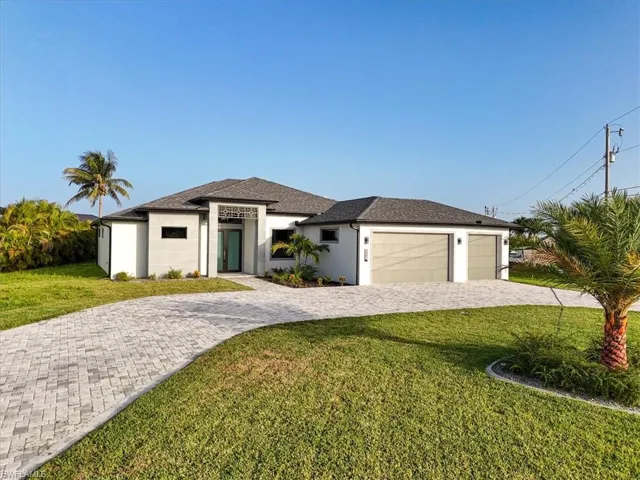 Prairie-style home with decorative driveway, a garage, stucco siding, a front yard, and roof with shingles