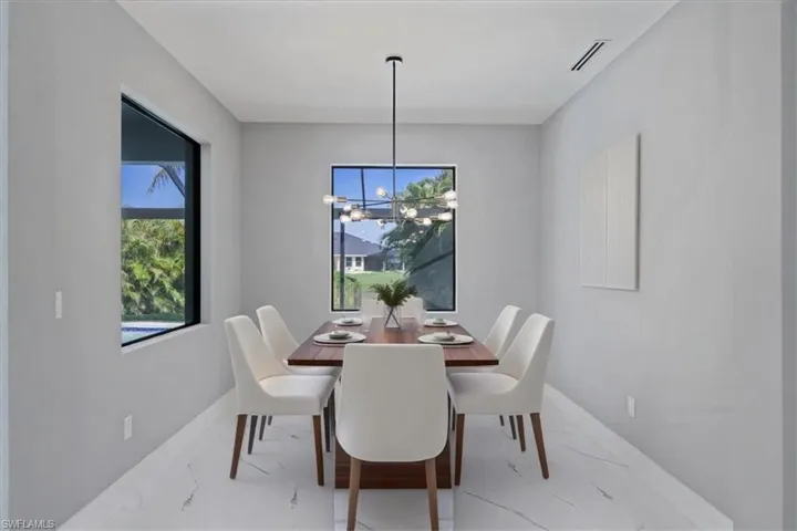 Dining space with light marble finish floors and a chandelier