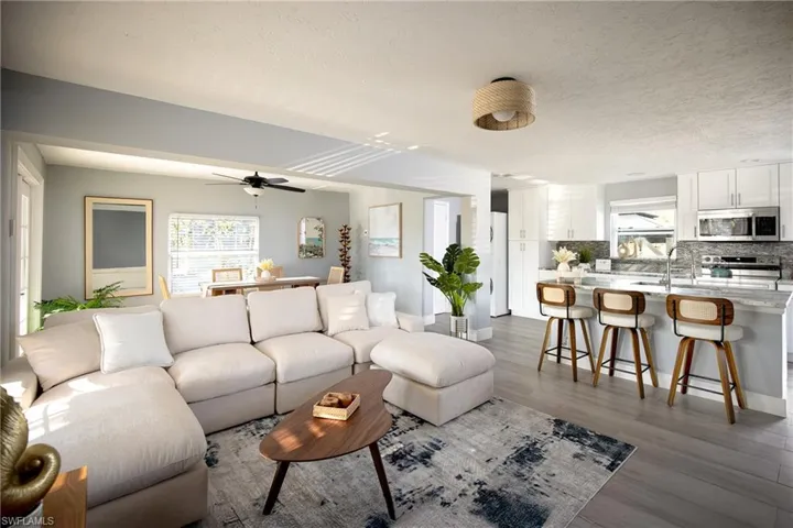 Living room featuring wood finished floors, a textured ceiling, and ceiling fan
