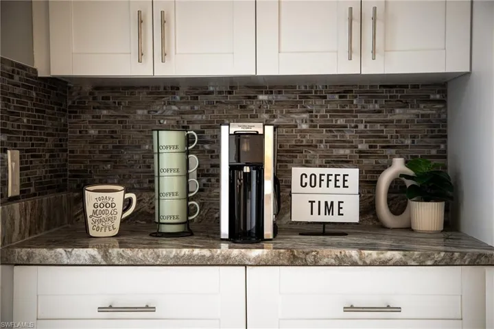 Kitchen view of white cabinets and decorative backsplash