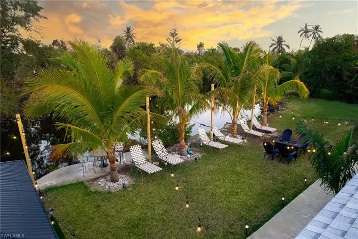 Yard at dusk featuring a lawn and a patio