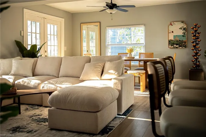 Living area with wood finished floors, healthy amount of natural light, and a ceiling fan