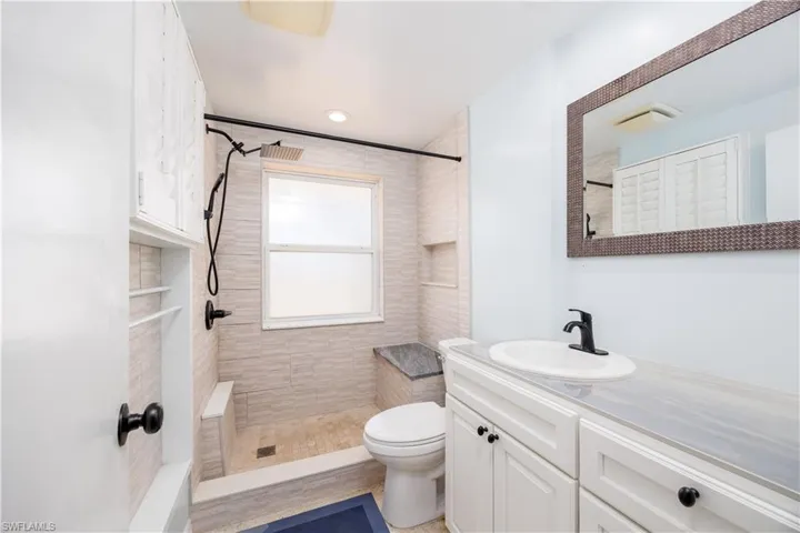 Full bath with vanity, toilet, and tiled shower