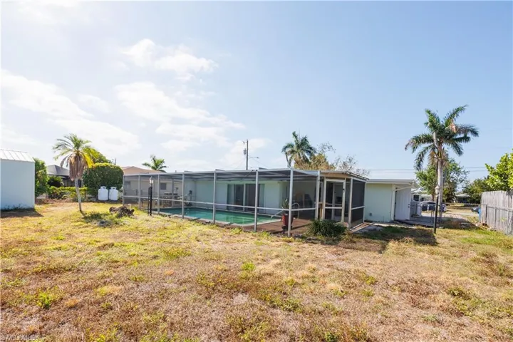 View of yard featuring glass enclosure, fence, and a fenced in pool
